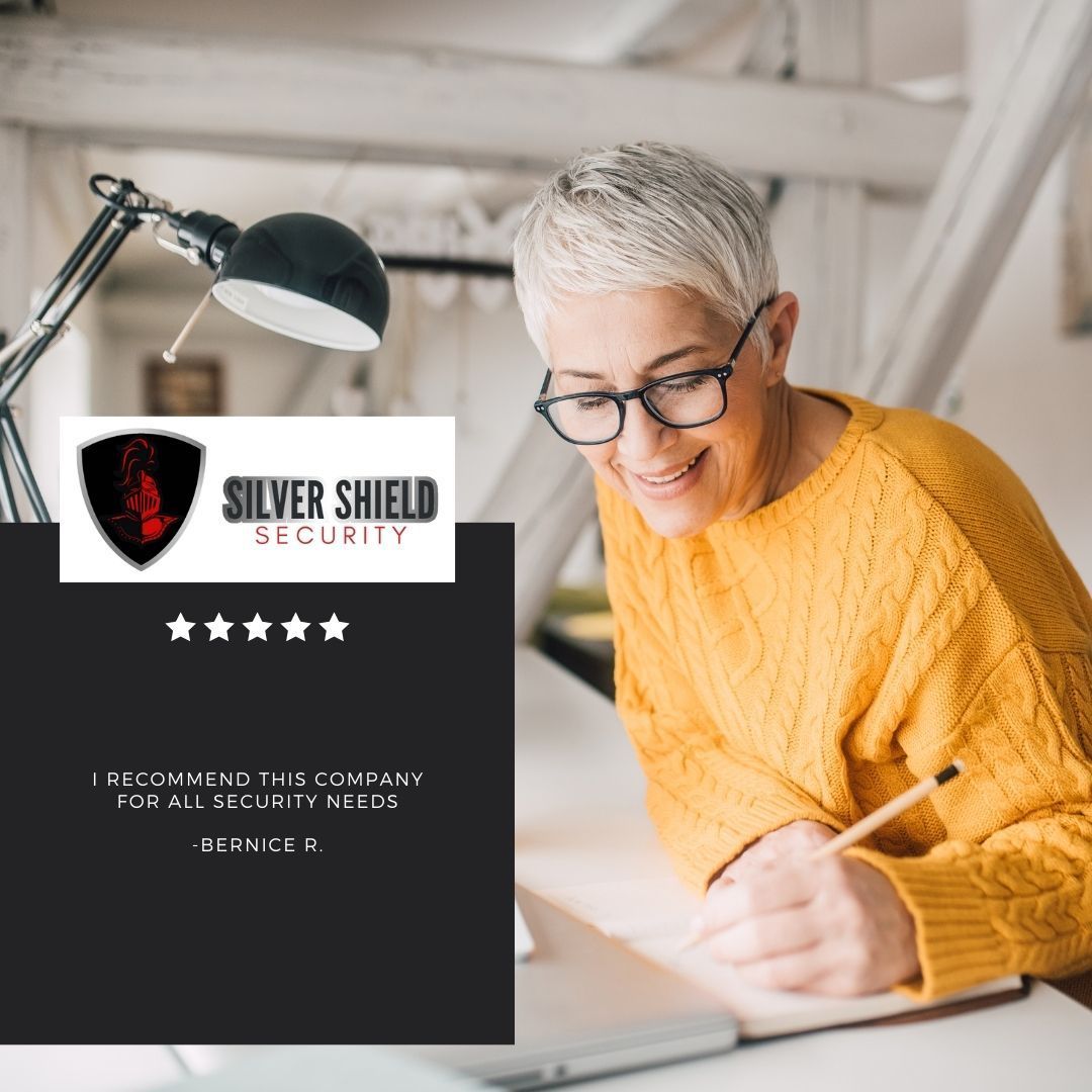 Silver Shield Security flyer beside a smiling person writing at a desk under a lamp