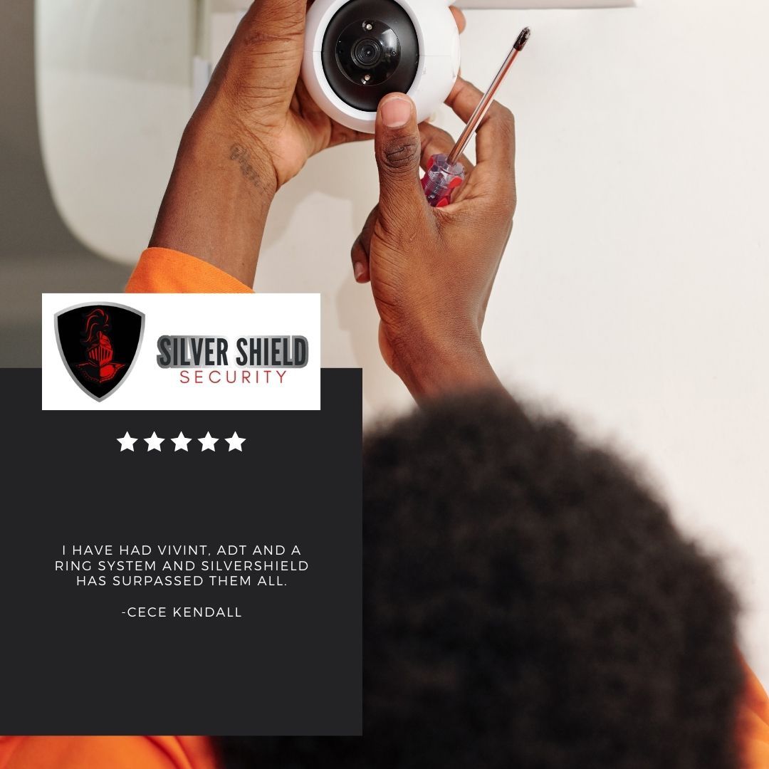 Security camera being installed above a Silver Shield Security ad with star rating.