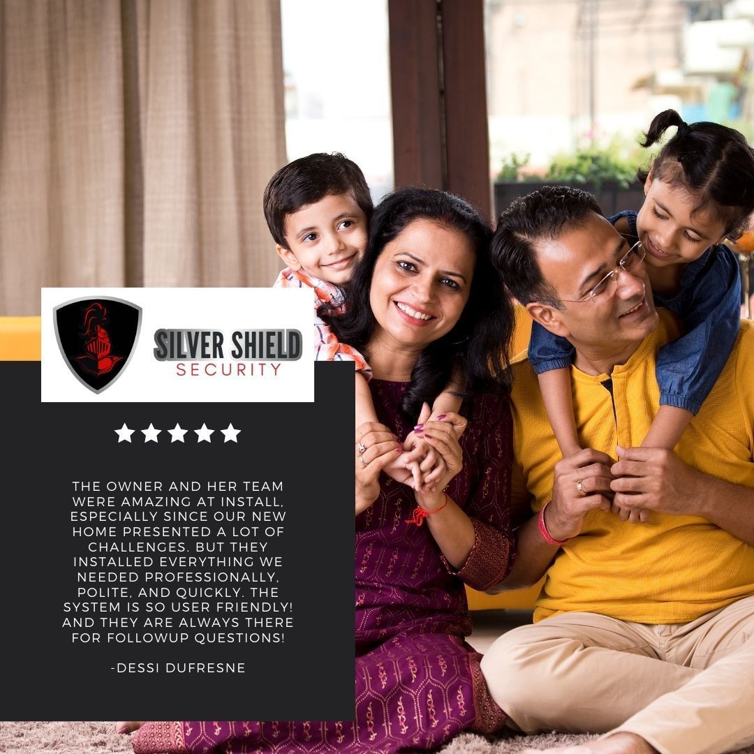 Happy family posing beside a Silver Shield Security advertisement poster.