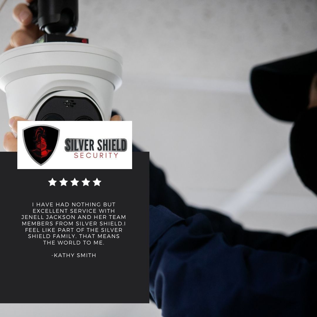 Silver Shield Security sign held by a person in a dark shirt