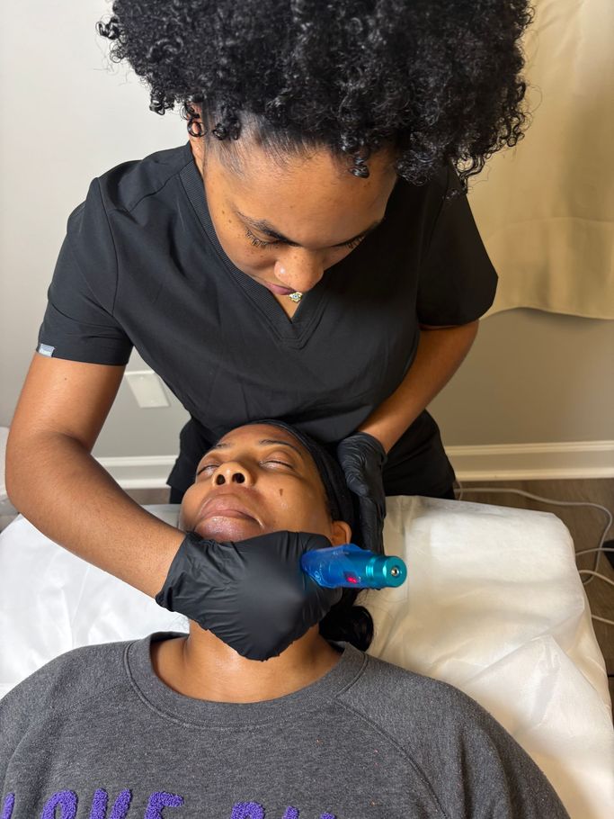 Person in black gloves holds another person's neck while using a blue handheld device in a treatment setting