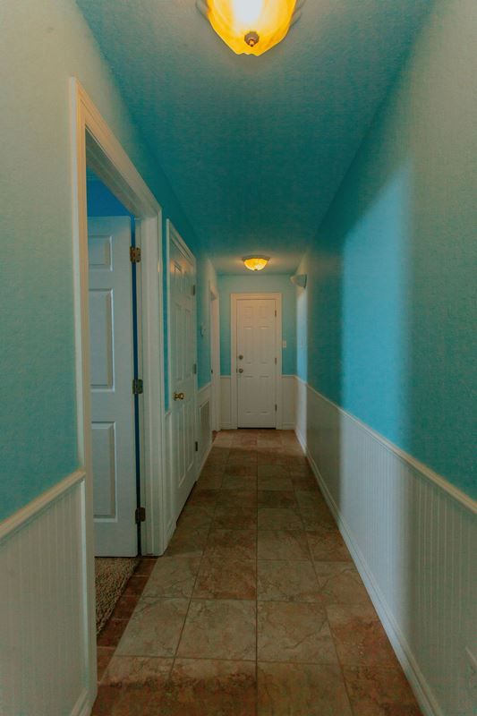 A hallway with blue walls and white trim