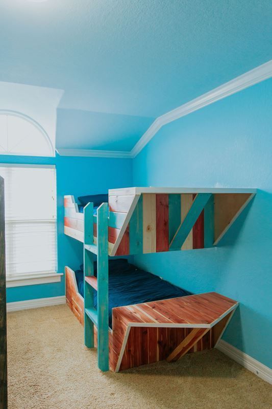 A bedroom with blue walls and a bunk bed.