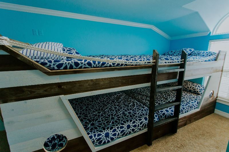 A bunk bed in a room with blue walls