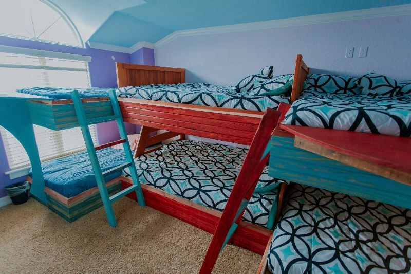 A bedroom with three bunk beds and a ladder.