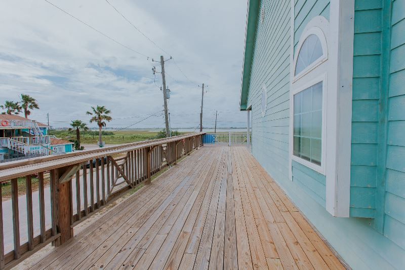 There is a large wooden deck on the side of a house.