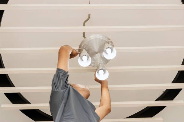 A worker installing lighting in a commercial space.
