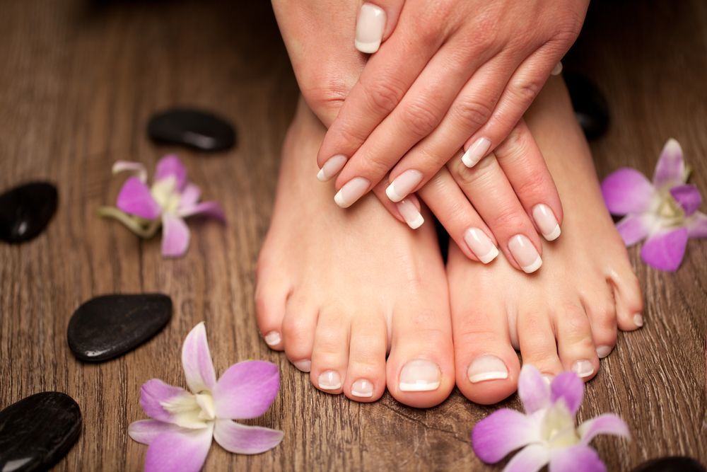 A Close Up of a Woman's Feet and Hands With Flowers and Rocks — Erikka's All Occasion Beauty In Rockhampton City, QLD
