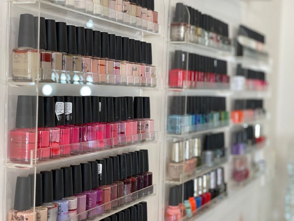 A Row of Shelves Filled With Bottles of Nail Polish in a Nail Salon — Erikka's All Occasion Beauty In Rockhampton City, QLD