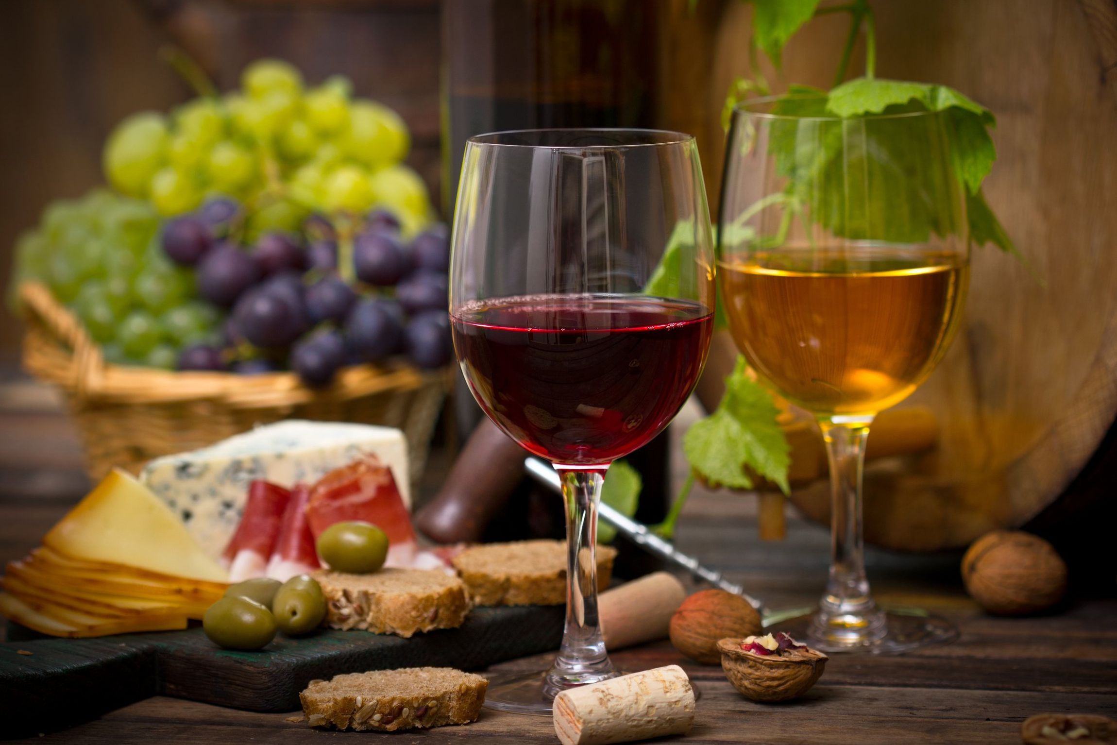 A glass of red wine sits on a table next to a glass of white wine