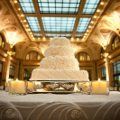 A wedding cake is sitting on top of a table in a room with candles.