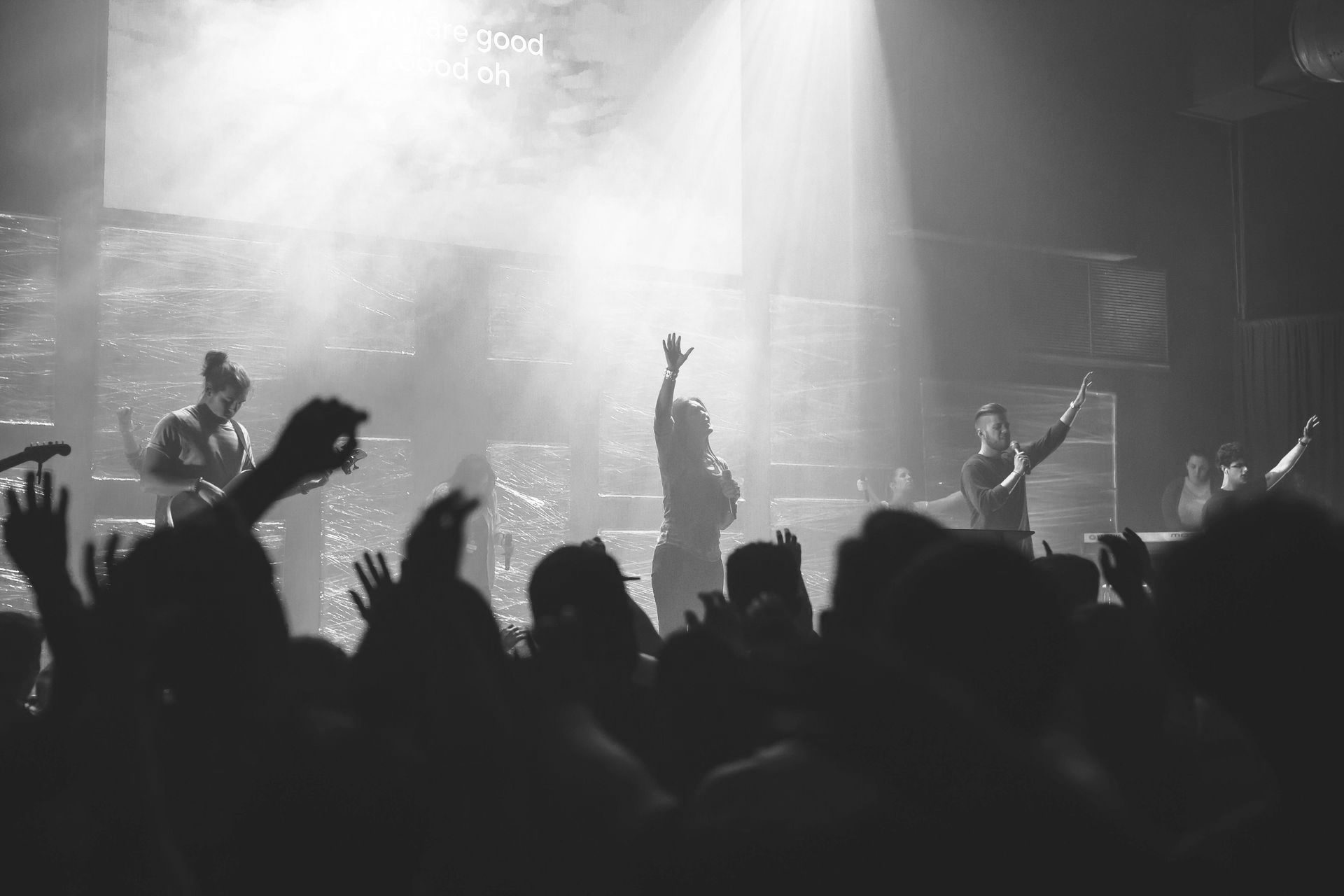 A crowd of people are standing in front of a stage at a concert.