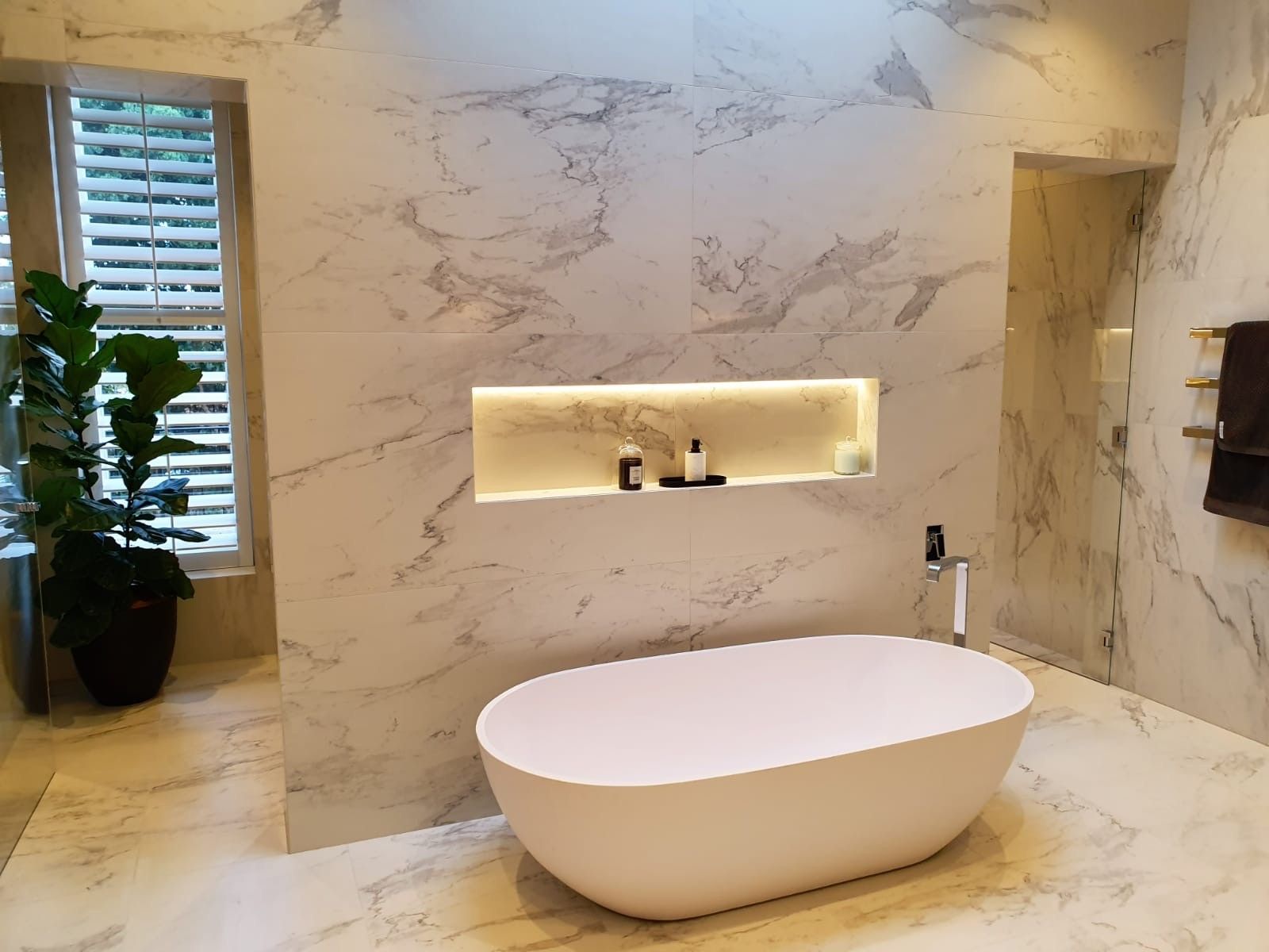 Small utility room with a glossy black floor, white walls, and a hatch or drain opening.