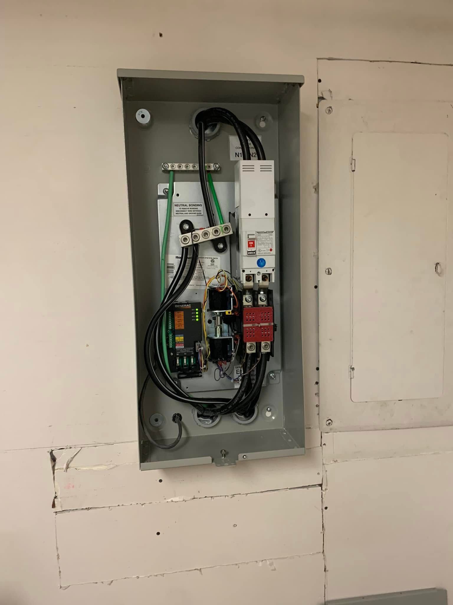 A electrical box is hanging on a white wall.