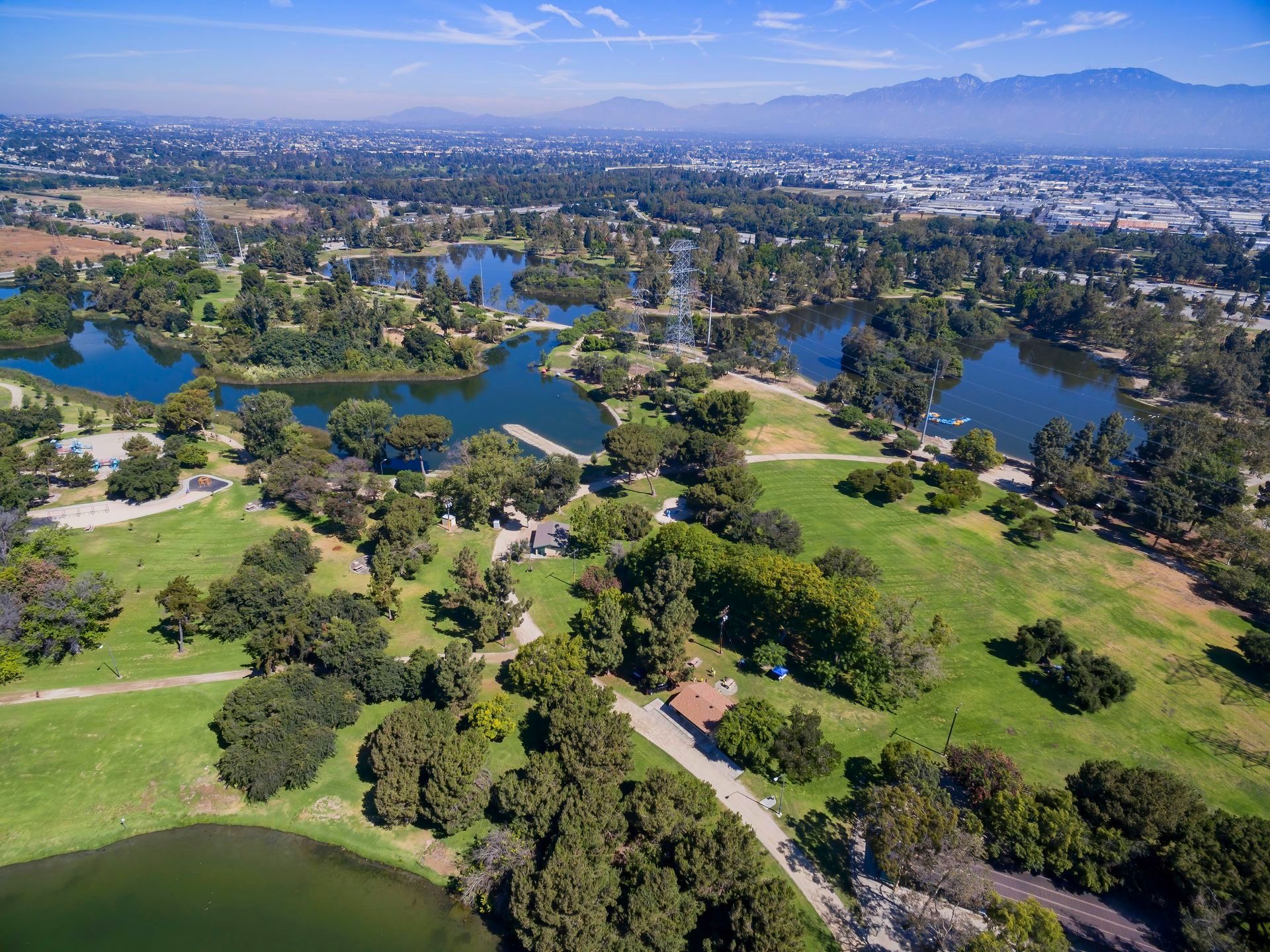 An aerial view of a park filled with lots of trees and lakes.