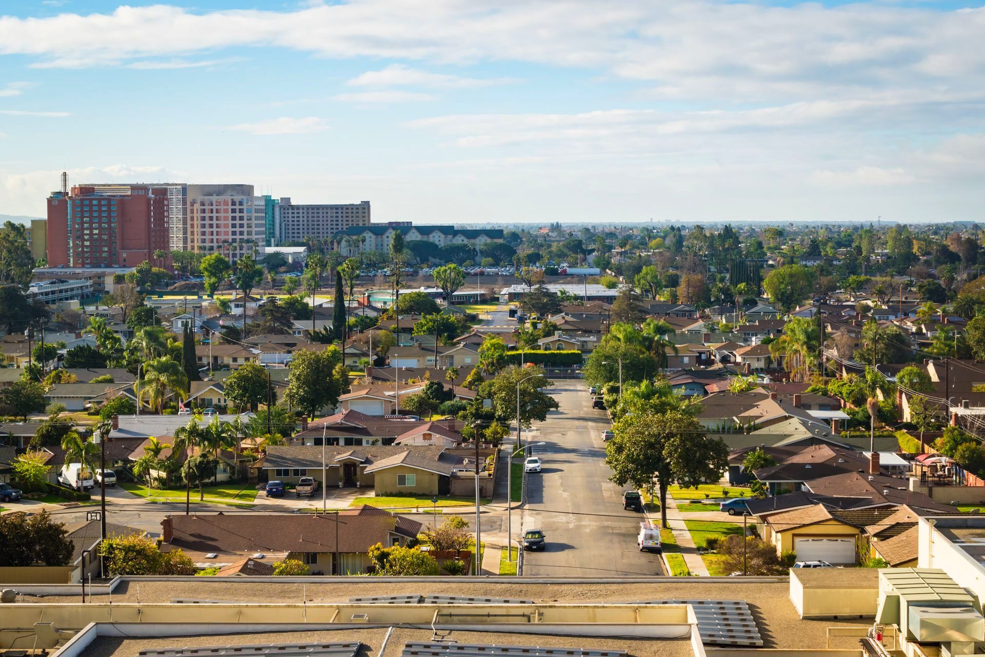 An aerial view of a residential area with a large building in the background