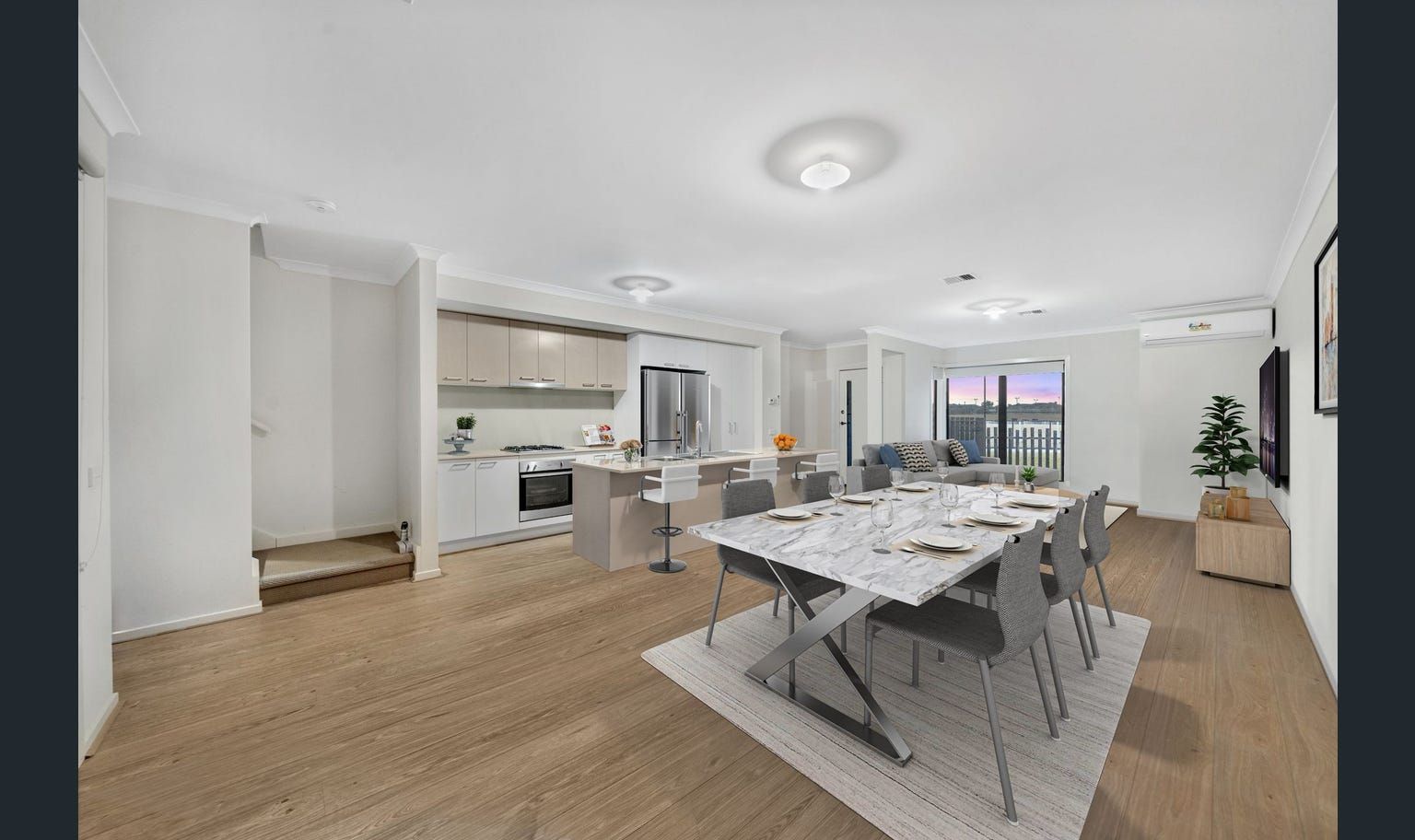 Open-plan kitchen and dining area with a marble-top table and neutral color scheme.