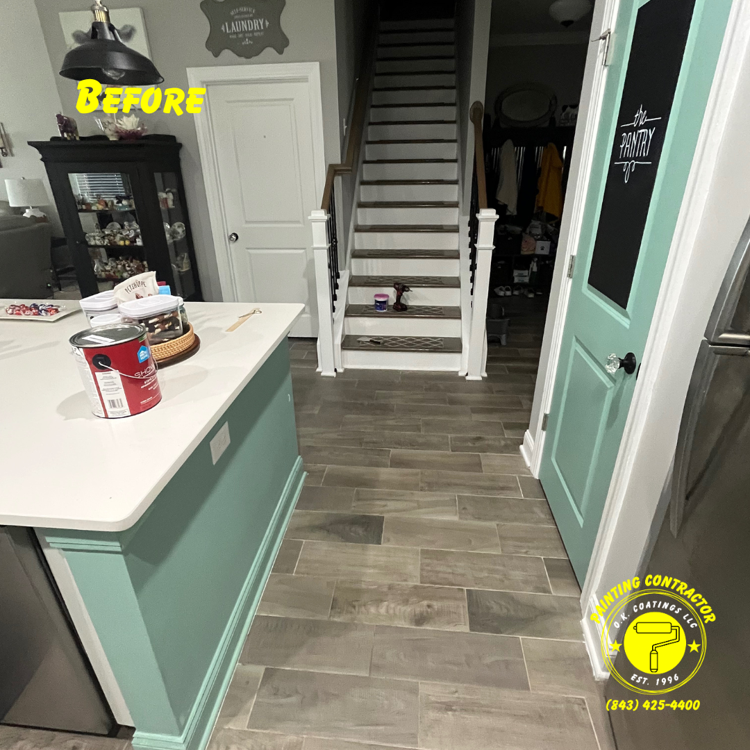 A kitchen island and a mint green door stand before a set of stairs, showcasing a residential interior remodeling project.