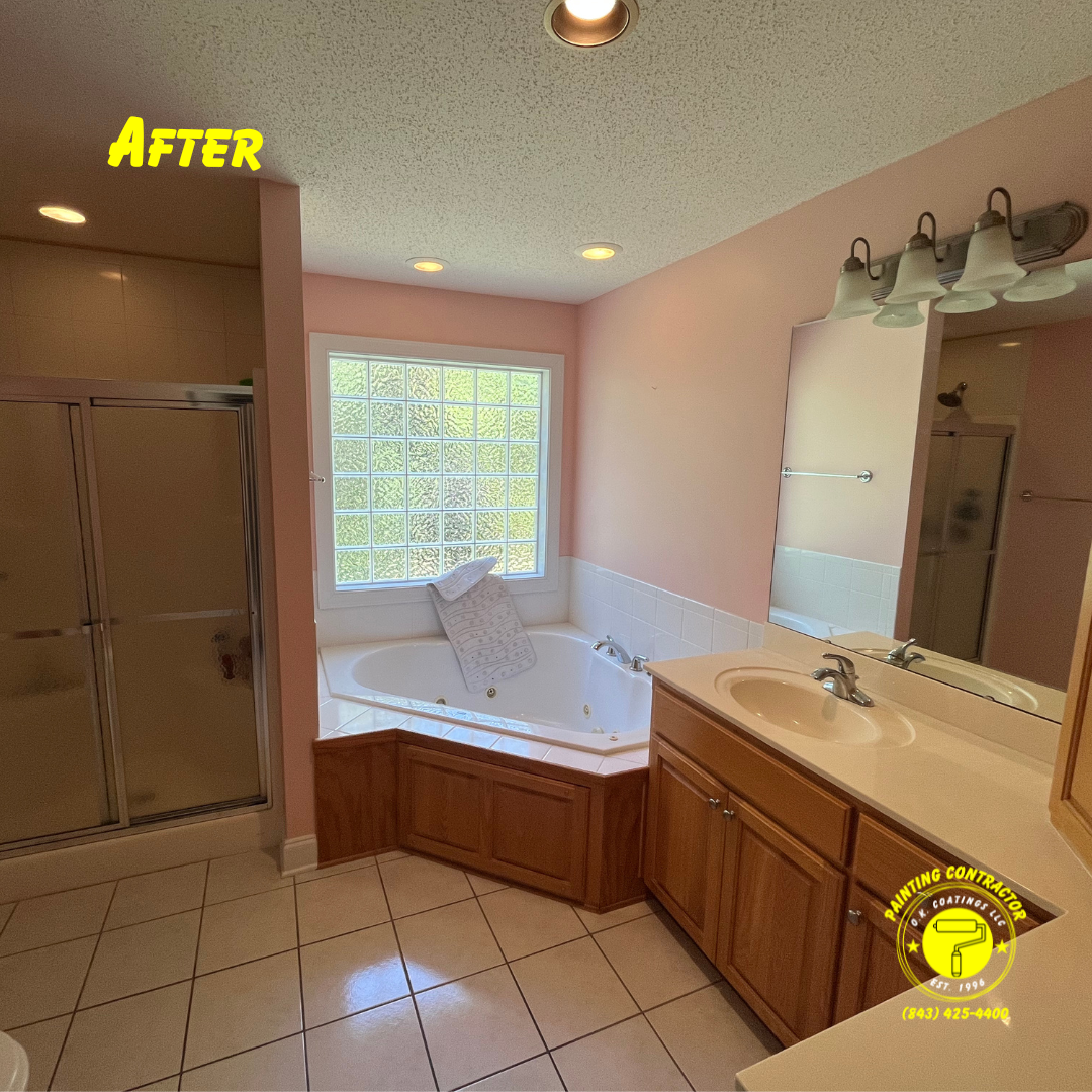 A bright, clean bathroom with tan walls, oak cabinets, a corner soaking tub, a glass shower, and a large vanity mirror.