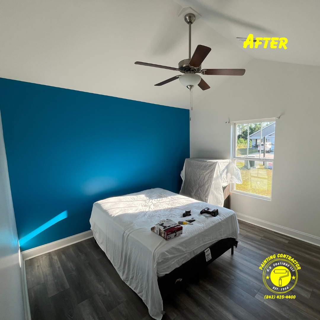 A bedroom featuring a bold teal accent wall, white walls, wood-look flooring, and a ceiling fan over a covered bed.