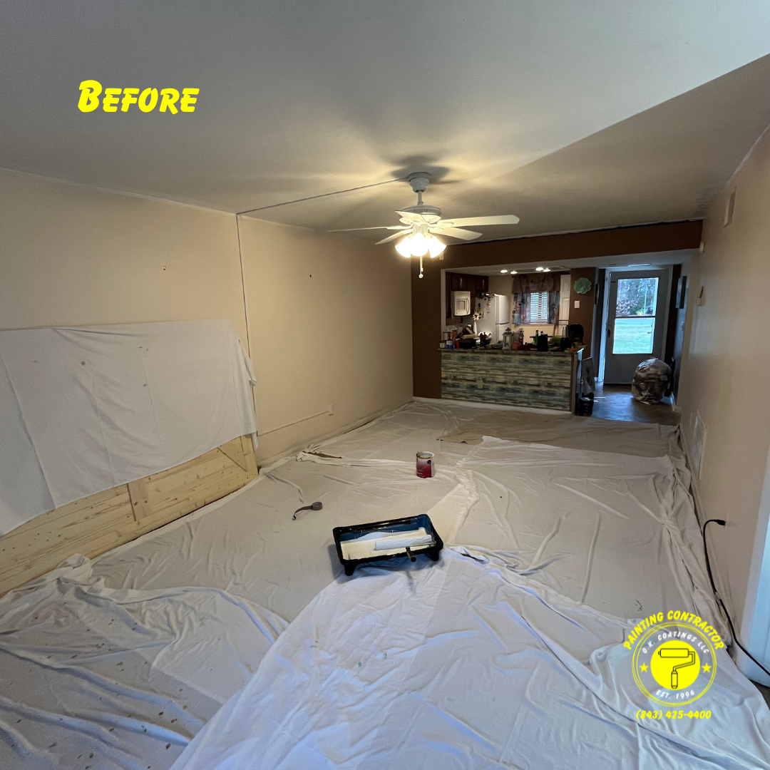 A room prepared for painting, with drop cloths covering the floor and a paint tray set in the center.