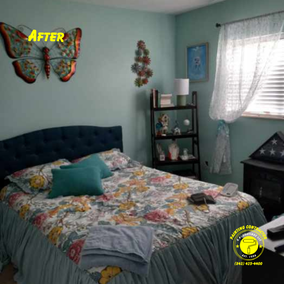 A bedroom with sage walls, a navy tufted headboard, floral bedding, a shelf with decor, and a large metal butterfly wall art.