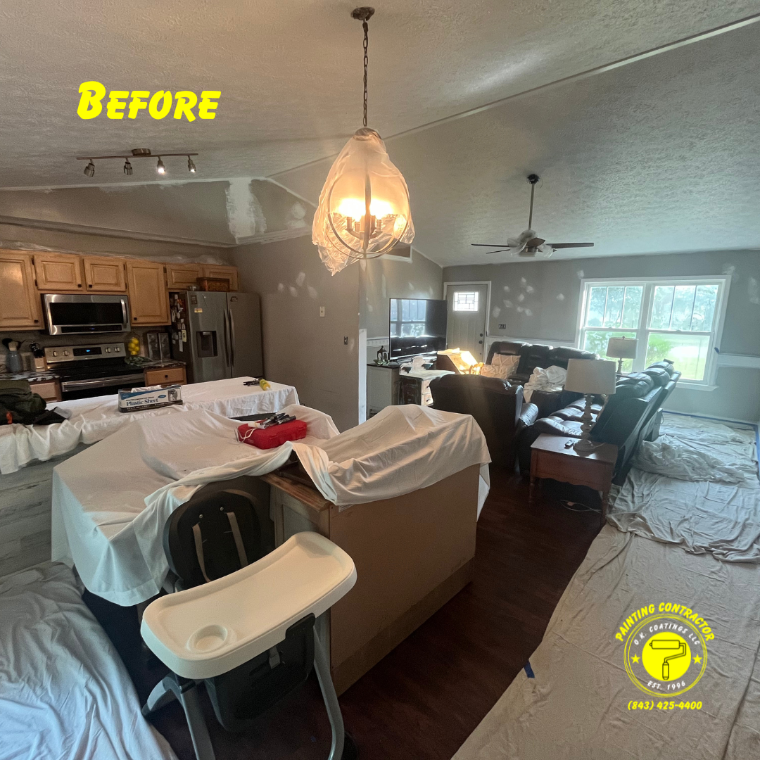 A living room and kitchen undergoing renovation, covered in drop cloths with paint spots on the walls, marked 