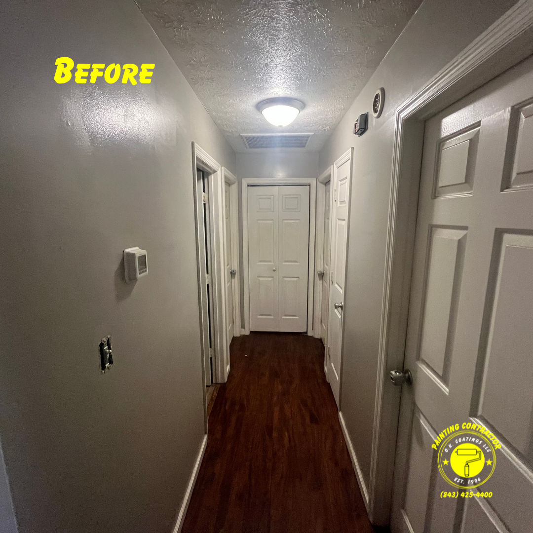 A narrow indoor hallway with white walls, multiple closed white doors, a textured ceiling, and dark wood-look flooring.