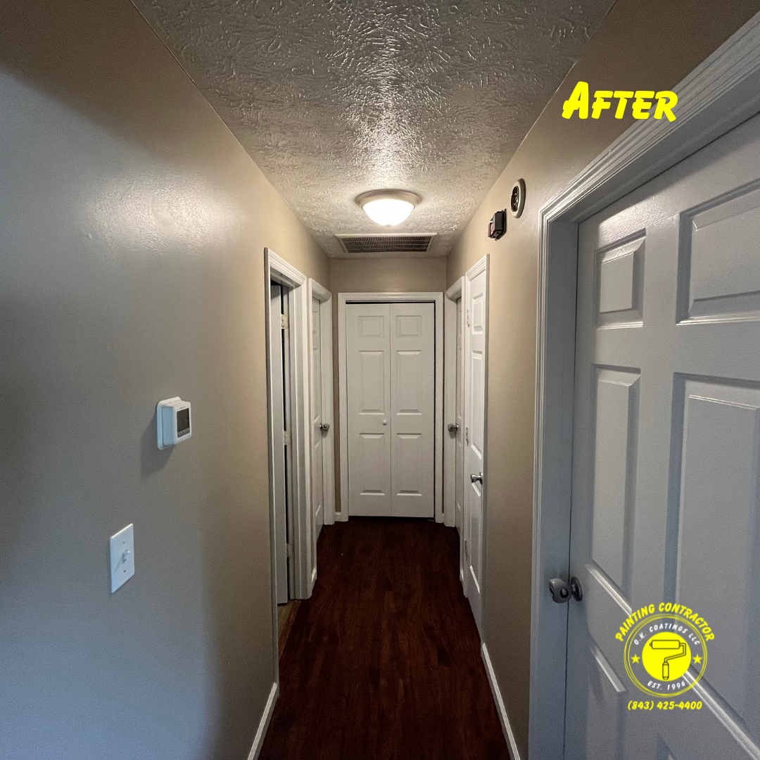 A narrow residential hallway featuring dark hardwood flooring, tan walls, white doors, and a ceiling-mounted light fixture.