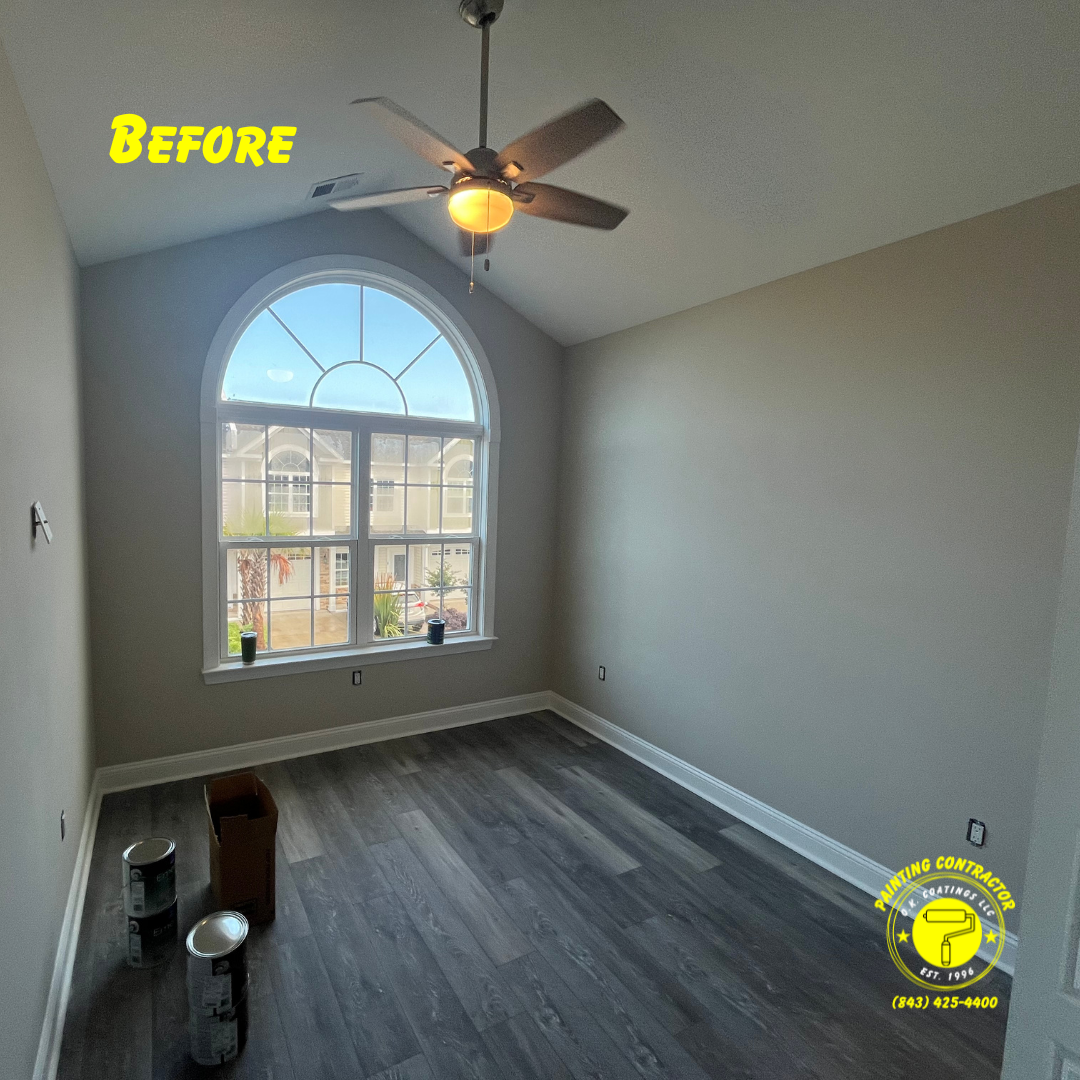 Empty room with grey walls, dark wood-look plank floors, a large arched window, and a ceiling fan, labeled 