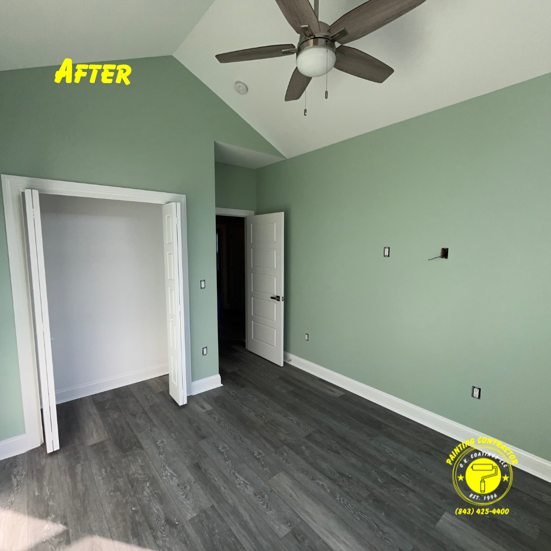 A bedroom with sage green walls, white trim, a ceiling fan, and dark gray wood-look flooring.