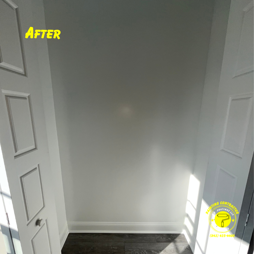A bright, freshly painted interior closet space with white walls, white trim, and dark wooden flooring.