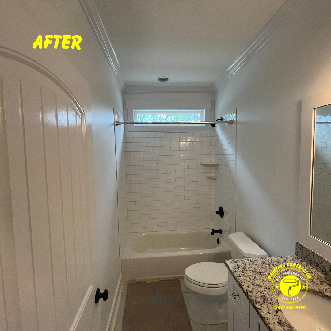 A renovated bathroom featuring a white subway tile shower, granite countertop, black hardware, and light gray walls.
