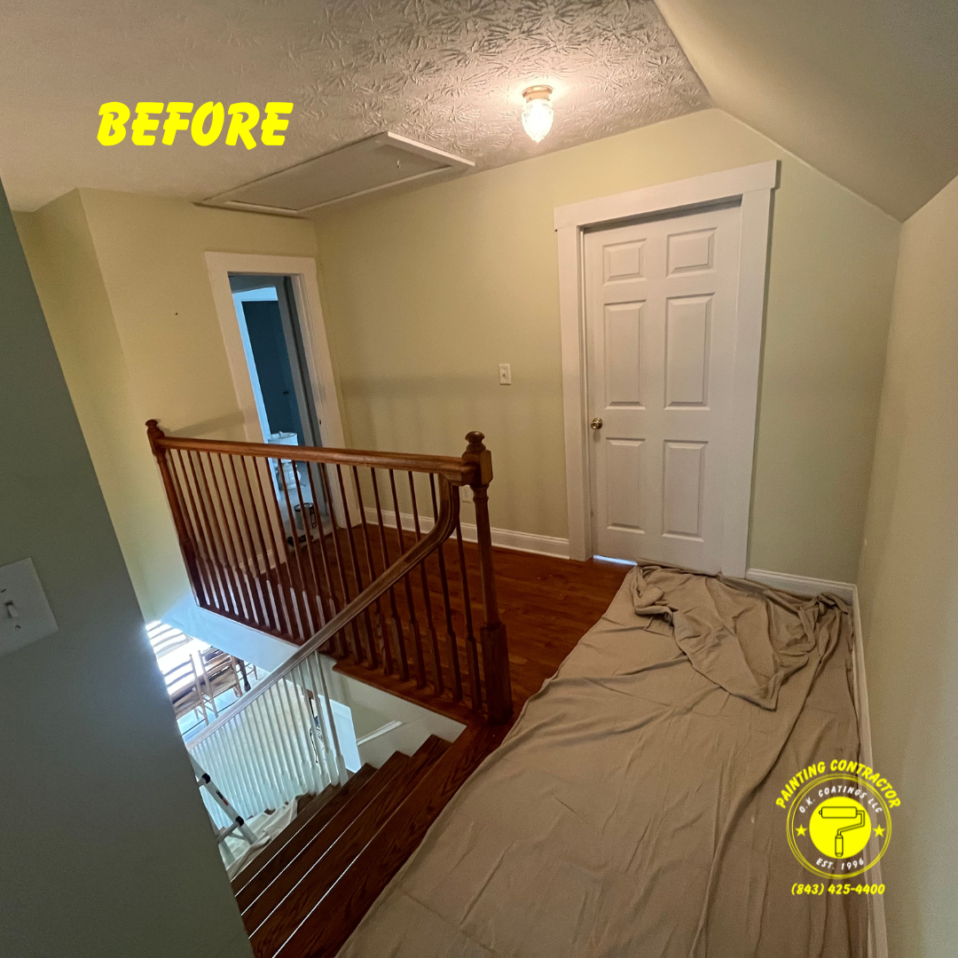 Before a room renovation showing wooden stairs, a landing with a wooden railing, a white door, and protective drop cloths.
