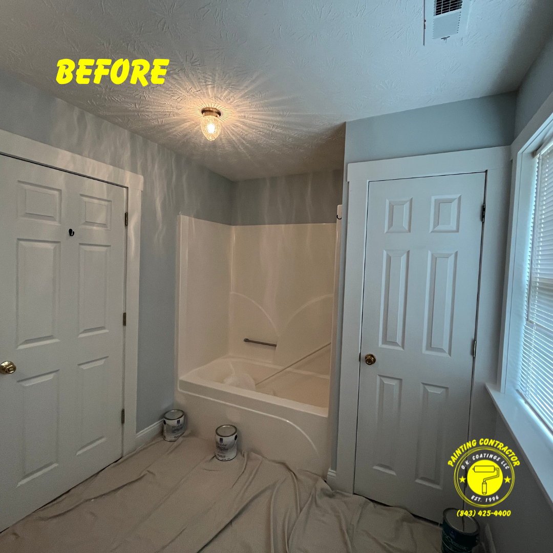 A room with grey walls, white doors, and a white bathtub, prepared for painting with a drop cloth on the floor.