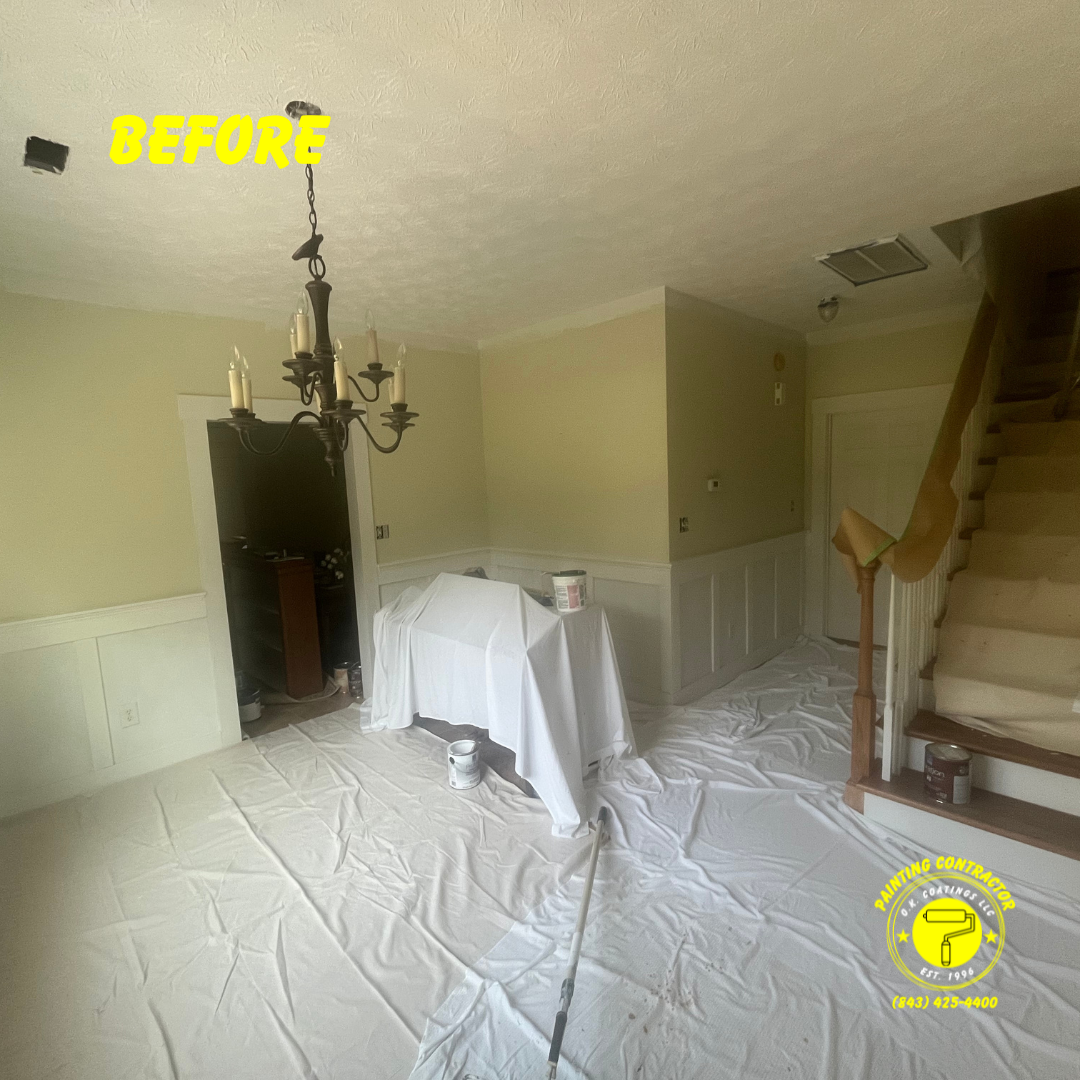 A home interior undergoing painting, with white drop cloths covering the floor and a covered table, before renovation.