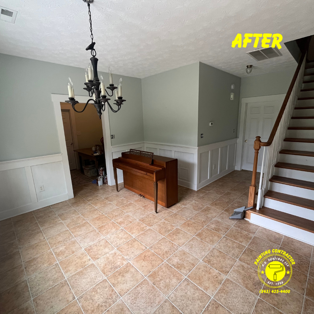 An interior room featuring light green walls, white wainscoting, a chandelier, a wooden piano, and a staircase.