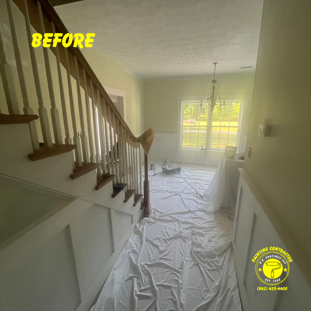An entryway with a staircase and wood-paneled walls covered by drop cloths, indicating a home renovation in progress.