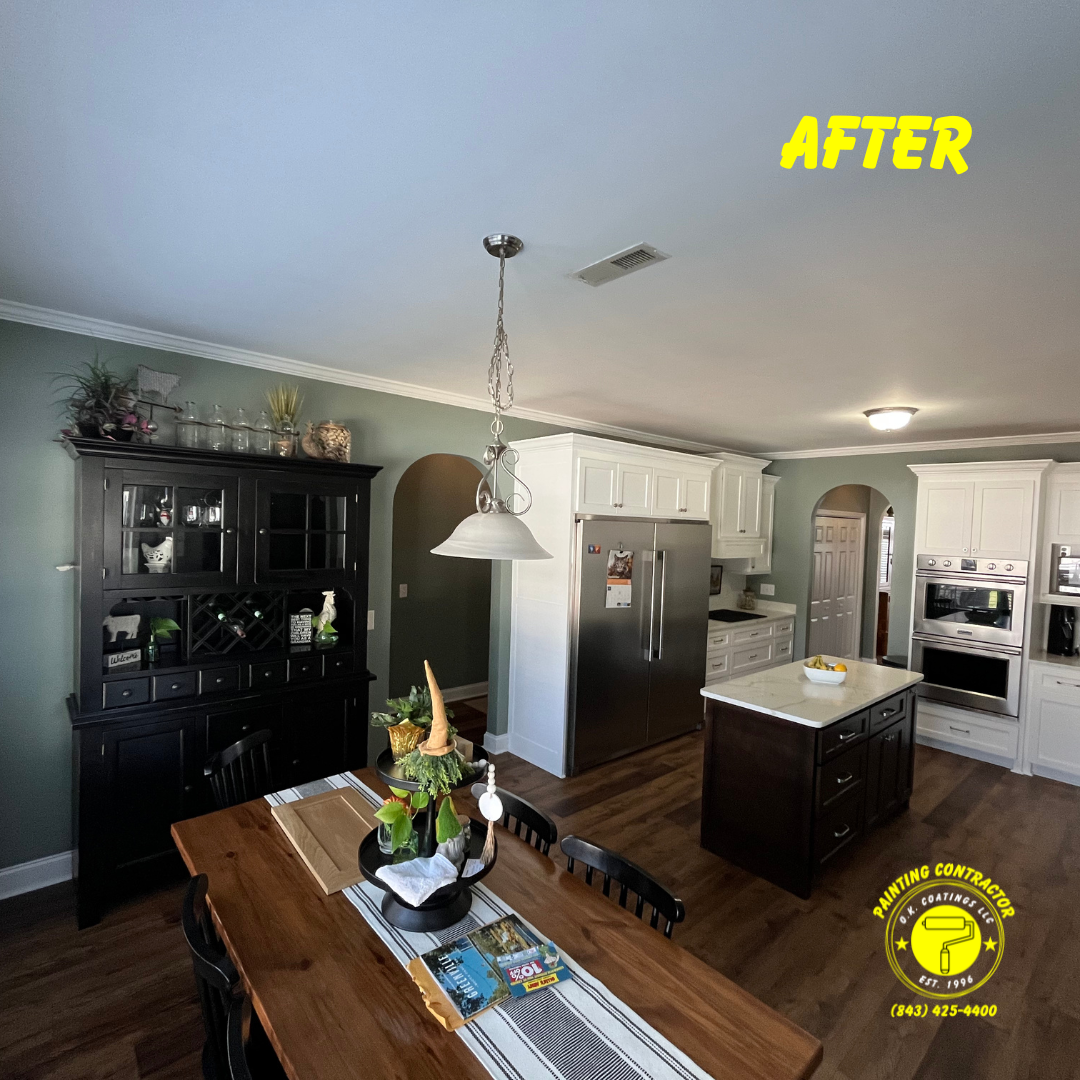 Kitchen interior with green walls, a black hutch, dining table, white cabinetry, and stainless appliances.