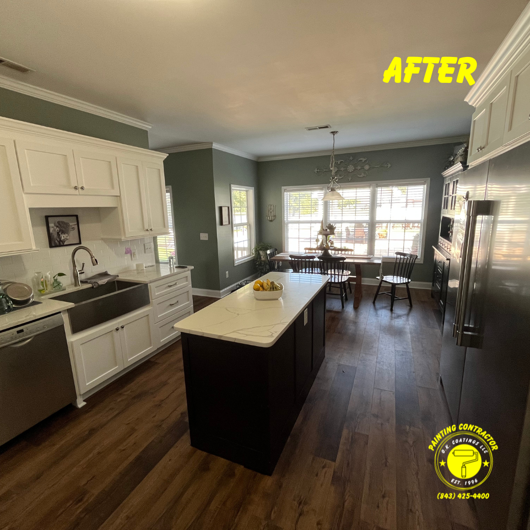 A renovated kitchen featuring white cabinets, a dark kitchen island with a white countertop, and dark wood floors.