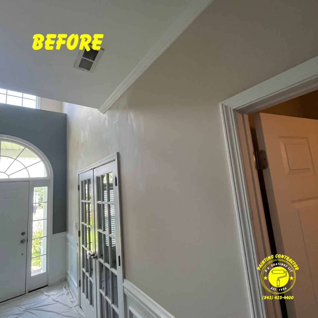 Interior view of a neutral-colored foyer and hallway with a white-framed doorway, French doors, and a bright entryway.