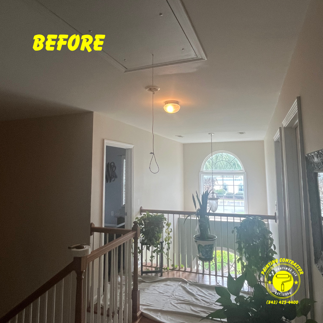 A stairwell landing with beige walls, an attic access hatch, and a hanging light fixture prepared for painting.