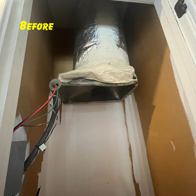 A view inside a wall cavity showing an HVAC duct with exposed wiring hanging near a rectangular metal opening.
