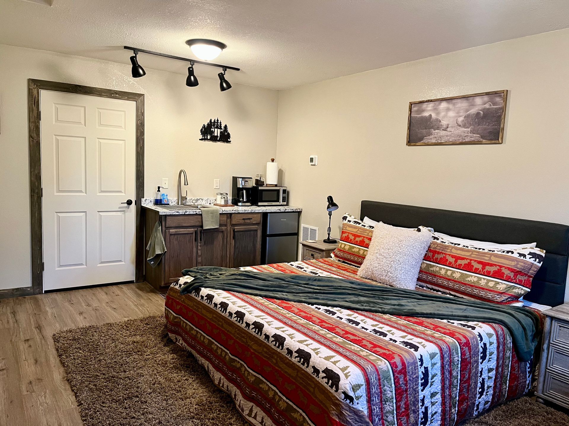 A bedroom with a king size bed and a kitchen.
