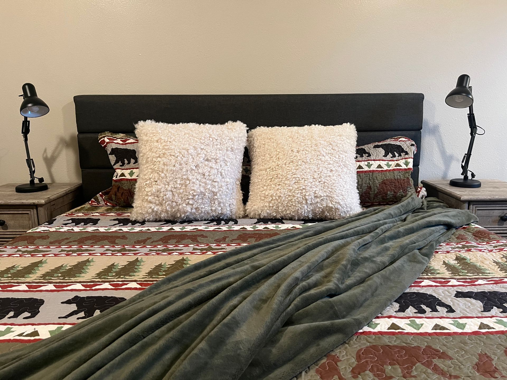 A bed with a blanket and pillows on it in a bedroom.