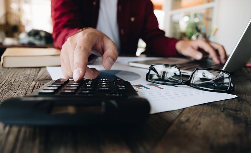A Man is Typing on a Laptop Computer While Using a Calculator — Rochdale Accounting & Business Advisory in Alstonville, NSW