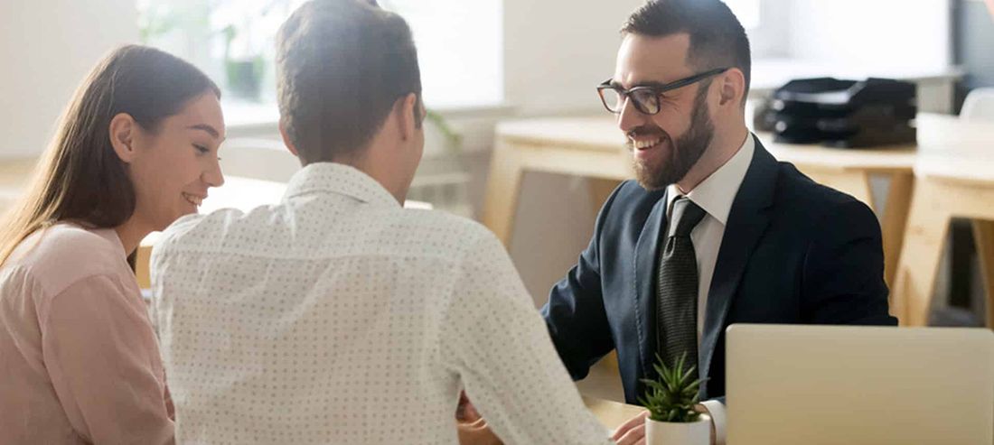 A Man in a Suit and Tie is Sitting at a Table With Two People — Rochdale Accounting & Business Advisory in Alstonville, NSW