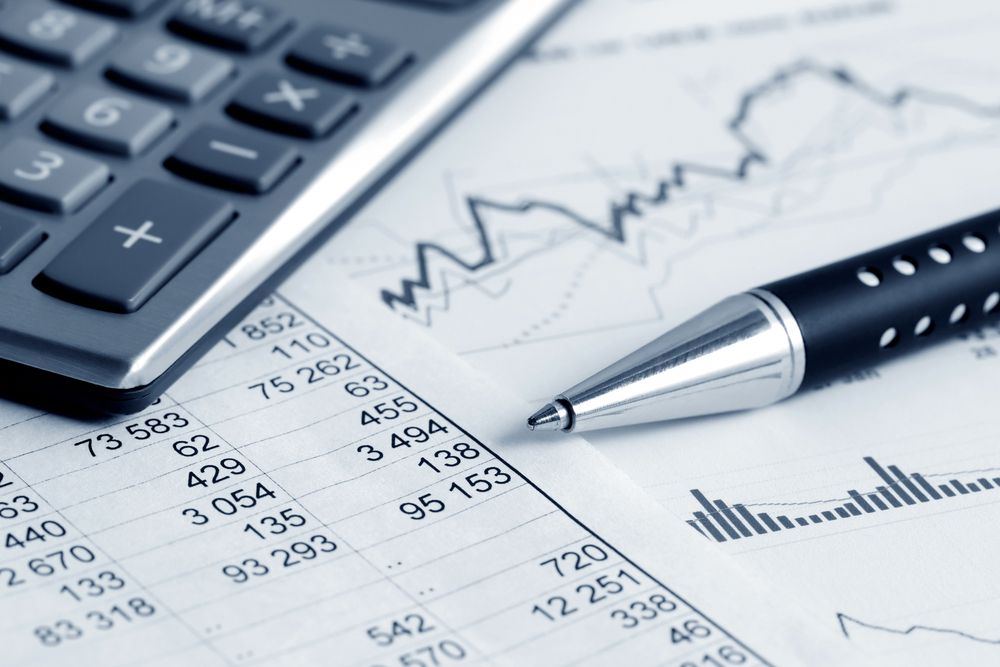 Calculator and pen on financial documents with charts and numbers — Rochdale Accounting & Business Advisory in Alstonville, NSW