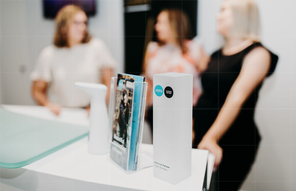 A Woman is Standing in Front of a Counter With a Brochure on It — Rochdale Accounting & Business Advisory in Alstonville, NSW