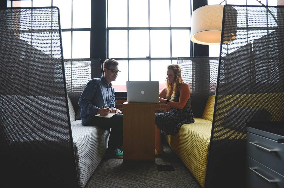 A Man and a Woman Are Sitting at a Table With a Laptop — Rochdale Accounting & Business Advisory in Alstonville, NSW